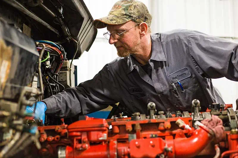 A man working on a truck engine at Mast Trucking company.